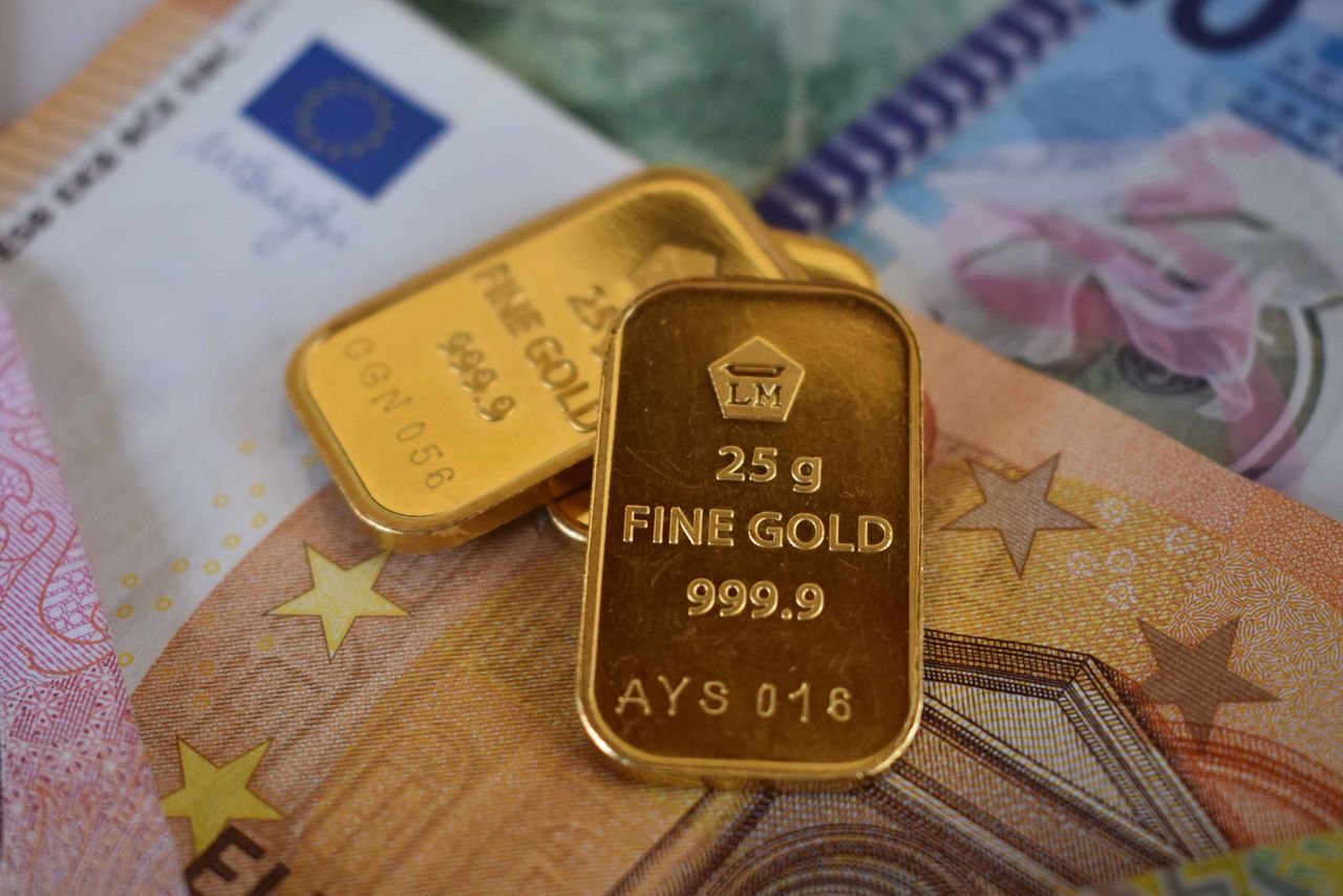 Home Close-up of two gold bars placed on Euro banknotes, emphasizing wealth and investment.